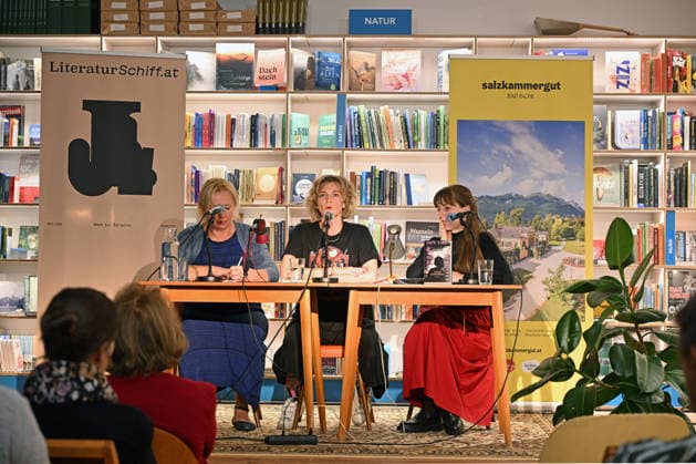 Minifestival AH0J (Literaturfestival) - Tschechien setzt über - der Kulturinitiative Literaturschiff, in der Buchhandlung Kurdirektion in Bad Ischl. Lesungen und Gespräche in Korrespondenz zum Gastauftritt Tschechiens auf der Frankfurter Buchmesse 2026. Es liest die tschechische Schriftstellerin und Magnesia Litera Preisträgerin Lucie Faulerova. Die Veranstaltung wird moderiert von Julia Miesenböck., fotografiert am 01.10.26. Das Bild zeigt v.l.n.r.: Übersetzerin Ladislava Baxant-Cenjar, Schriftstellerin Lucie Faulerova, Moderatorin Julia Miesenböck vor Publikum 2026 - Minifestival AH0J (Literaturfestival) - Tschechien setzt über - der Kulturinitiative Literaturschiff, in der Buchhandlung Kurdirektion in Bad Ischl. Lesungen und Gespr