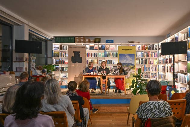 Minifestival AH0J (Literaturfestival) - Tschechien setzt über - der Kulturinitiative Literaturschiff, in der Buchhandlung Kurdirektion in Bad Ischl. Lesungen und Gespräche in Korrespondenz zum Gastauftritt Tschechiens auf der Frankfurter Buchmesse 2026. Es liest die tschechische Schriftstellerin und Magnesia Litera Preisträgerin Lucie Faulerova. Die Veranstaltung wird moderiert von Julia Miesenböck., fotografiert am 01.10.26. Das Bild zeigt v.l.n.r.: Übersetzerin Ladislava Baxant-Cenjar, Schriftstellerin Lucie Faulerova, Moderatorin Julia Miesenböck vor Publikum 2026 - Minifestival AH0J (Literaturfestival) - Tschechien setzt über - der Kulturinitiative Literaturschiff, in der Buchhandlung Kurdirektion in Bad Ischl. Lesungen und Gespr