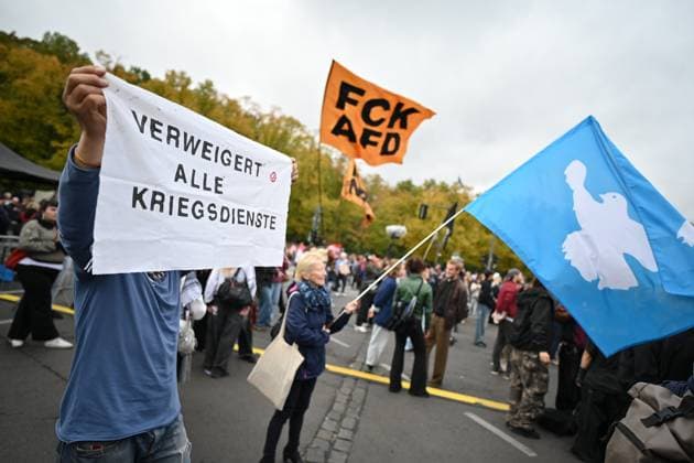 Menschen protestieren am 02.10.2026 vor dem Brandenburger Tor unter dem Motto Unzwingbar - Kein Bock auf Krieg und Wehrpflicht . Zu den Veranstaltern der Demonstration zaehlen unter anderem Attac, die Deutsche Friedensgesellschaft und der Internationale Jugendverband. In einem vorab verbreiteten Aufruf stellten sich die Organisationen etwa gegen eine Wiedereinfuehrung der Wehrpflicht und die Anwerbung Jugendlicher unter 18 Jahren fuer die Bundeswehr. Das Buendnis forderte zudem mehr Geld fuer Bildung, Gesundheit und Soziales statt fuer Krieg. Angekuendigt waren Redebeitraege unter anderem von Gewerkschaftern, Schueler- und Studentengruppen und der Schulstreikbewegung. Daneben sollte es Auftritte mehrerer Bands und Musiker geben. (Siehe epd Copyright: epd-bild ChristianxDitsch 16