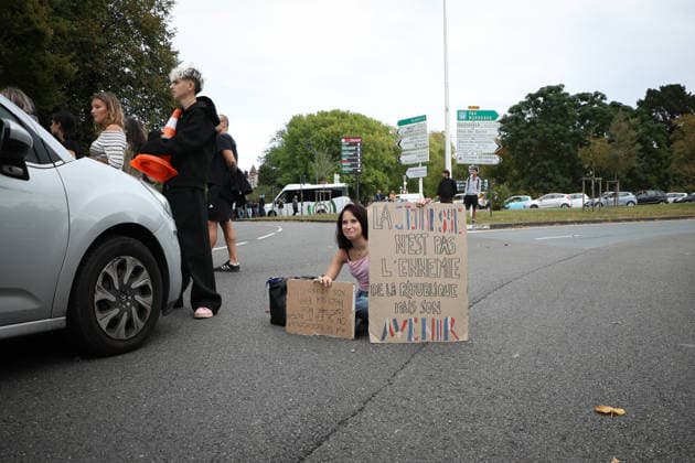 October 2, 2026, Bayonne, Nouvelle Aquitaine, France: A young protester sits on the road to block traffic, holding a cardboard sign reading Youth is not the enemy of the Republic but its future , during a demonstration in Bayonne, southwestern France, on October 2, 2026, against overcrowded classes and a lack of resources. The movement, which began in the Paris region a week ago, has spread across France, with hundreds of high schools blocked. Bayonne France - ZUMAb298 20261002_zsp_b298_002 Copyright: xJulesxBuonx