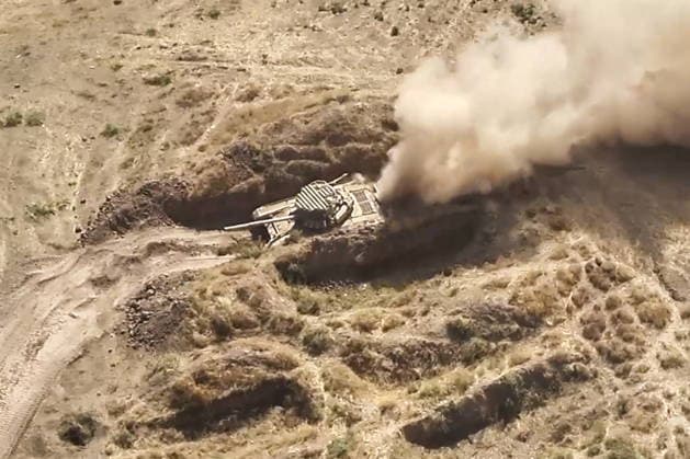 TAJIKISTAN - OCTOBER 3, 2026: Russian tank crews destroy a simulated enemy during the Tsentr Centre 2026 military exercise held at the Lyaur training ground. Video screen grab. Best quality available. Russian Defence Ministry TASS  98708970