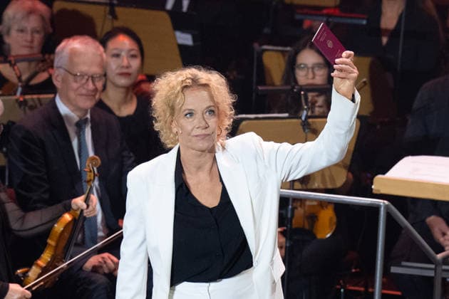 German Unity Day Ceremony in Bremen: Actress Katja Riemann shows her German passport at the German Unity Day ceremony at the Glocke in Bremen, October 3, 2026, Bremen, Germany