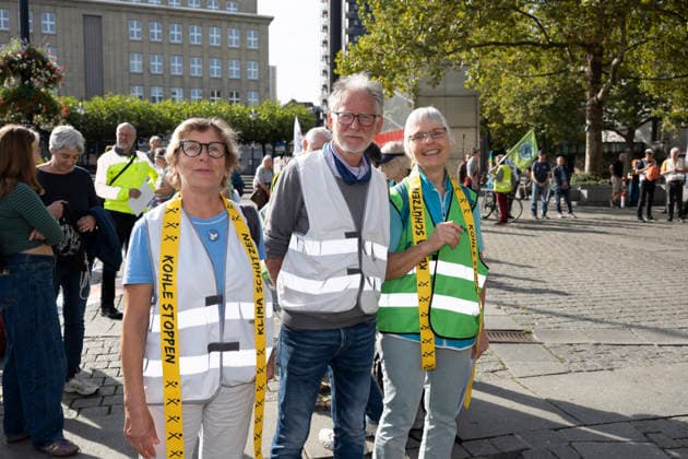 October 3, 2026 Press event: Es brennt Initiative human chain in Dortmund, Hansaplatz; from left: Annette Budde, Hans Rogalli, and Sabine Dorschnik from the Dortmund Climate Alliance responded to the call; Dortmund, Hansaplatz and Westenhellweg, North Rhine-Westphalia, Germany