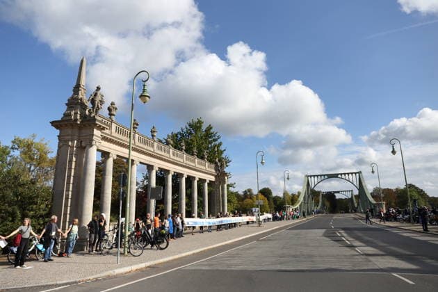 Protesters during a human chain for climate protection and democracy on the Glienicker Bridge in Potsdam, October 3, 2026. It s on fire —human chain in Potsdam