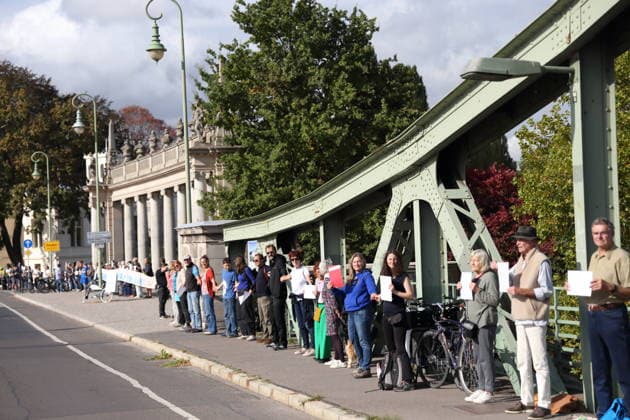 Protesters during a human chain for climate protection and democracy on the Glienicker Bridge in Potsdam, October 3, 2026. It s on fire —human chain in Potsdam