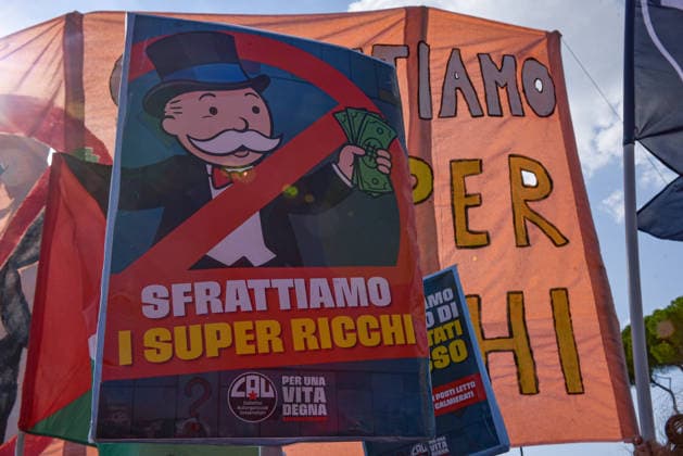 October 3, 2026, Rome, Rome, Italy: A protester holds a sign calling to evict the super-rich during the Potere al Popolo demonstration at Piazza Bocca della Verità in Rome on October 3, 2026. Rome Italy - ZUMAn299 20261003_zip_n299_015 Copyright: xVincenzoxNuzzolesex