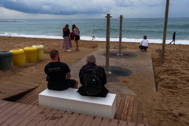 Red alert for extreme weather in Barcelona, Spain. Two men on the seafront during ES-Alert for extreme weather in Promenade, Barcelona, Spain, on October 3, 2026. Barcelona Promenade Barcelona Spain