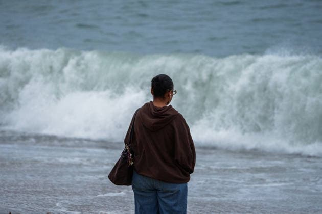 Red alert for extreme weather in Barcelona, Spain. Woman in front of the sea during ES-Alert for extreme weather in Promenade, Barcelona, Spain, on October 3, 2026. Barcelona Promenade Barcelona Spain
