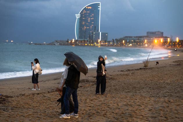 Red alert for extreme weather in Barcelona, Spain. People walking and taking photos along the Sant Sebastià Beach during red alert for extreme weather in Promenade, Barcelona, Spain, on October 3, 2026. Barcelona Promenade Barcelona Spain