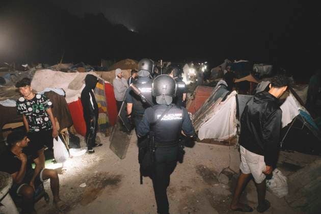 October 3, 2026, Ceuta, Ceuta, Spain: Riot police officers move between the shelters of a makeshift migrant camp in Ceuta at night. Riot police escorted firefighters through the camp on the night of October 3 to put out the fires that people living there use to cook their food. Thousands of migrants, most of them young Moroccan men, have been living in makeshift settlements in the Spanish North African enclave of Ceuta since a mass arrival at the end of July 2026 set off a migration and political crisis. Ceuta Spain - ZUMAs392 20261003_zip_s392_013 Copyright: xFabianxSuspensivox