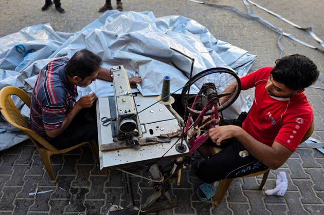 Palestinian Tailor Repairs Tent Covers for Displaced Families in Khan Younis Palestinian tailor Shaaban al-Tabash repairs and assembles tarpaulins and plastic sheets using rudimentary methods to reinforce the tents of displaced Palestinians and protect them from cold weather and rain in Khan Younis, in the southern Gaza Strip, on October 4, 2026. As winter approaches, shortages of protective supplies and the deterioration of many tents after nearly three years of war are worsening living conditions, while al-Tabash uses available materials to extend the life of shelters that have become the last refuge for thousands of displaced people. Photo by Tariq Mohammad APA Images Khan Yunis Gaza Strip Palestinian Territory 041026_Khan_Yunis_TM_01( Copyright: xapaimagesxTariqxMohammad xapaimagesx