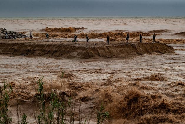 October 4, 2026, Sant Adria Del Besos, Barcelona, Spain: People stays at the mouth of the Besos River, north of Barcelona, swollen and laden with sediment after a night of torrential rain across Catalonia. The storm brought exceptional rainfall to the Barcelona metropolitan area, with more than 200 litres per square metre recorded in parts of the region. The Besos rose sharply overnight, prompting authorities to warn of an imminent risk of flooding. Sant Adria Del Besos Spain - ZUMAb137 20261004_fap_b137_002 Copyright: xJordixBoixareux