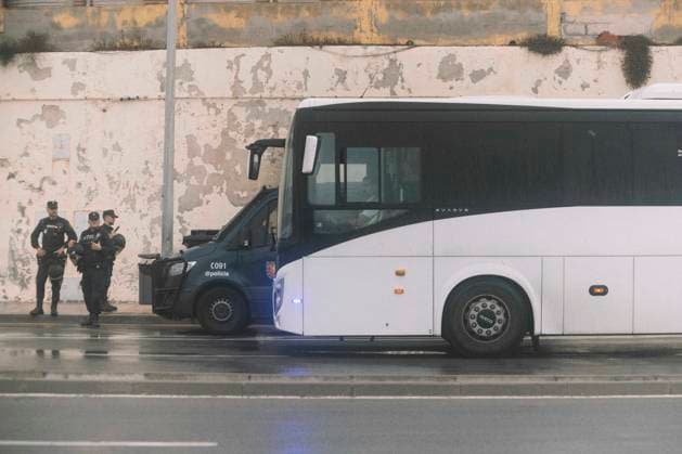 October 4, 2026, Ceuta, Ceuta, Spain: Police officers stand next to a bus by a peeling wall near El Trampolin beach in Ceuta during the eviction of the makeshift migrant camp. Spanish National Police began evicting the makeshift camp on El Trampolin beach in Ceuta on October 4, where more than 3,000 migrants, most of them young Moroccan men, were living. Dozens of police vans, armoured vehicles of the Police Intervention Units (UIP), drones and boats took part in the operation. People were taken by bus to the temporary centre at the Tarajal border to be identified, and the authorities plan to clear the beach in phases before October 15. The camp grew after a mass arrival at the end of July 2026 set off a migration and political crisis. Ceu  - ZUMAs392 20261004_zip_s392_021 Copyright: xFabianxSuspensivox