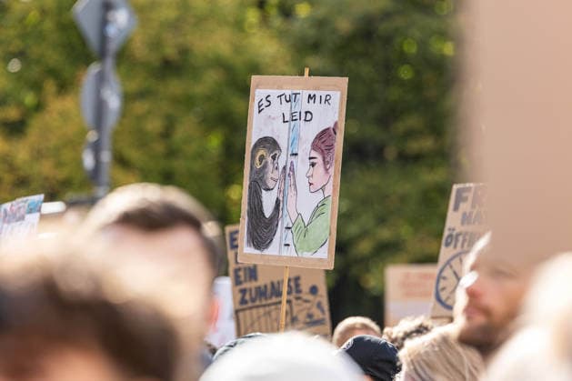 Robert Marc Lehmann at the Anti-Zoo Demonstration in Berlin, Berlin, Germany, October 4, 2026 A homemade protest sign reading I’m sorry at the F*CK ZOOS demonstration depicts a drawn scene between a human and a monkey. Other demonstrators and signs can be seen in the background. Berlin, Germany, Berlin