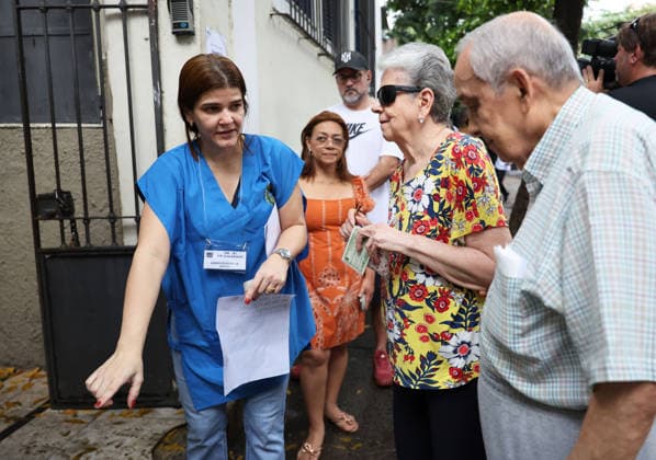 (261004) -- BRASILIA, Oct. 4, 2026 -- A staff member guides voters at a polling station in Rio de Janeiro, Brazil, Oct. 4, 2026. Voting in the first round of Brazil s 2026 presidential election officially began at 8 a.m. (1100 GMT) on Sunday, with polling stations across the country scheduled to close at 5 p.m. (0800 GMT). Initial results are expected to be announced within a few hours after the polls close. ) BRAZIL-PRESIDENTIAL ELECTION-VOTING JinxHaoyuan 