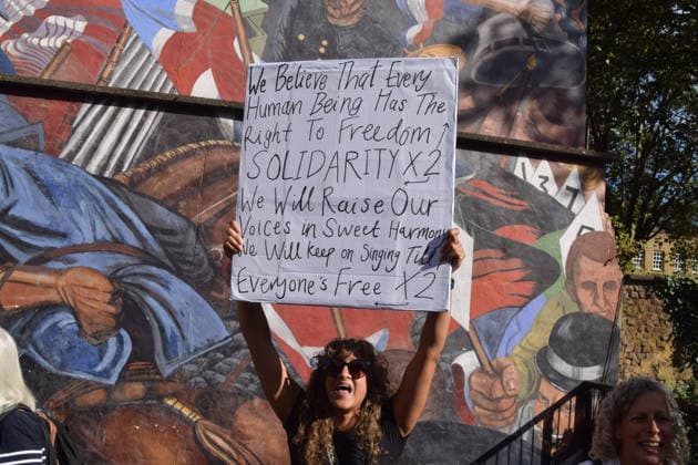 October 4, 2026, London, England, United Kingdom: Protesters pass by the Cable Street Mural, painted by Dave Binnington, Paul Butler, Ray Walker and Desmond Rochfort between 1979 and 1983, during the march against racism and fascism, marking the 90th anniversary since the Battle of Cable Street. London United Kingdom  - ZUMAv130 20261004_zip_v130_069 Copyright: xVukxValcicx