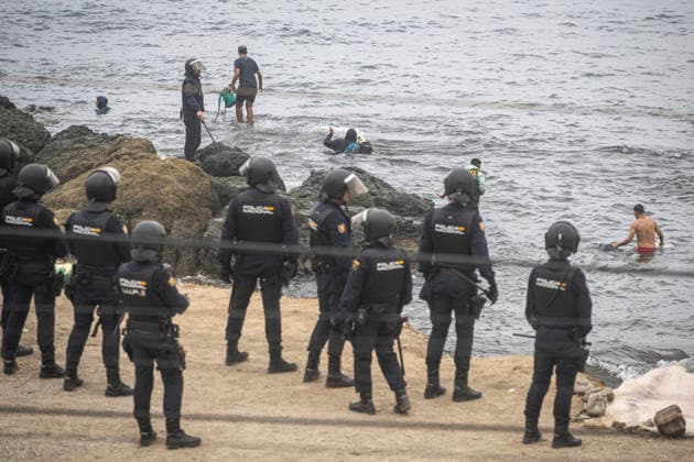 The migrants evicted from El Trampolín are divided between those who return to Morocco and those who prefer to register. National Police officers intervene during the eviction of the group of migrants gathered on El Trampolín Beach on October 4, 2026, in Ceuta, Spain. The National Police escort buses full of migrants evicted from El Trampolín Beach toward the Tarajal border area, where some choose to stay at the Temporary Care Center for Foreigners (CATE) in order to be registered and subsequently accommodated, while others prefer to return to Morocco on foot and voluntarily. OCTOBER 4, 2026 MIGRATION CRISIS Ceuta, Spain  Copyright: xMarcosxMorenox 7820576