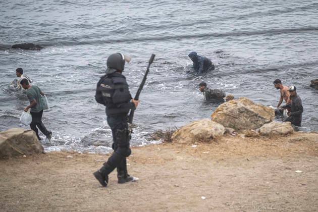 The migrants evicted from El Trampolín are divided between those who return to Morocco and those who prefer to register. National Police officers intervene during the eviction of the group of migrants gathered on El Trampolín Beach on October 4, 2026, in Ceuta, Spain. The National Police escort buses full of migrants evicted from El Trampolín Beach toward the Tarajal border area, where some choose to stay at the Temporary Care Center for Foreigners (CATE) in order to be registered and subsequently accommodated, while others prefer to return to Morocco on foot and voluntarily. OCTOBER 4, 2026 MIGRATION CRISIS Ceuta, Spain  Copyright: xMarcosxMorenox 7820579