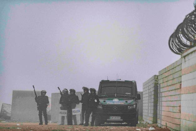 October 4, 2026, Ceuta, Ceuta, Spain: Riot police officers and a police van stand by a wall topped with razor wire in the fog during the eviction of the makeshift migrant camp on El Trampolin beach in Ceuta. Spanish National Police began evicting the makeshift camp on El Trampolin beach in Ceuta on October 4, where more than 3,000 migrants, most of them young Moroccan men, were living. Dozens of police vans, armoured vehicles of the Police Intervention Units (UIP), drones and boats took part in the operation. People were taken by bus to the temporary centre at the Tarajal border to be identified, and the authorities plan to clear the beach in phases before October 15. The camp grew after a mass arrival at the end of July 2026 set off a migr - ZUMAMigr 20261004_zip_s392_009 Copyright: xFabianxSuspensivox