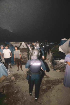 October 3, 2026, Ceuta, Ceuta, Spain: A riot police officer walks through a makeshift migrant camp in Ceuta at night. Riot police escorted firefighters through the camp on the night of October 3 to put out the fires that people living there use to cook their food. Thousands of migrants, most of them young Moroccan men, have been living in makeshift settlements in the Spanish North African enclave of Ceuta since a mass arrival at the end of July 2026 set off a migration and political crisis. Ceuta Spain - ZUMArefi 20261003_zip_s392_010 Copyright: xFabianxSuspensivox