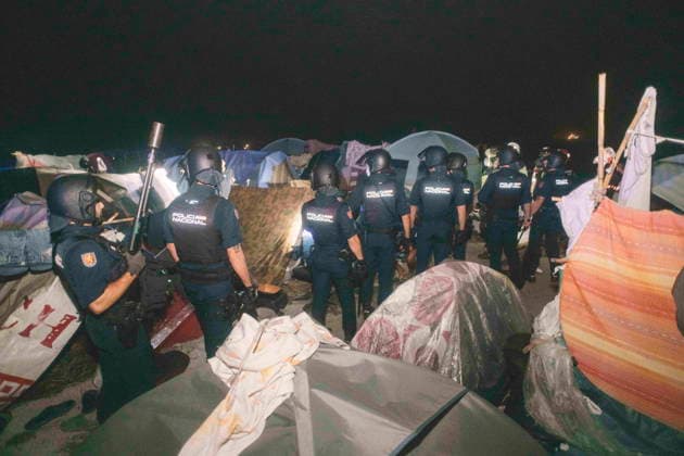 October 3, 2026, Ceuta, Ceuta, Spain: Riot police officers stand among the tents of a makeshift migrant camp in Ceuta at night. Riot police escorted firefighters through the camp on the night of October 3 to put out the fires that people living there use to cook their food. Thousands of migrants, most of them young Moroccan men, have been living in makeshift settlements in the Spanish North African enclave of Ceuta since a mass arrival at the end of July 2026 set off a migration and political crisis. Ceuta Spain - ZUMArefi 20261003_zip_s392_015 Copyright: xFabianxSuspensivox