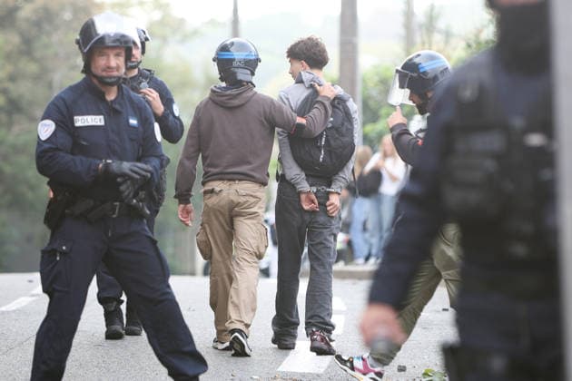 October 5, 2026, Anglet, Nouvelle Aquitaine, France: Police officers from the anti-crime brigade (BAC) detain a handcuffed youth who had been hiding in bushes during a protest by high school students against the government outside the Cantau high school in Anglet, southwestern France, on October 5, 2026. Students have been blocking schools across France since September 21 to demand more teachers, smaller classes and better school buildings. Cantau was closed by authorities after clashes in recent days. Anglet France  - ZUMAb298 20261005_zsp_b298_024 Copyright: xJulesxBuonx