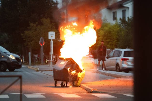 October 5, 2026, Anglet, Nouvelle Aquitaine, France: A waste container burns in the street as a man looks on during a protest by high school students against the government outside the Cantau high school in Anglet, southwestern France, on October 5, 2026. Students have been blocking schools across France since September 21 to demand more teachers, smaller classes and better school buildings. Cantau was closed by authorities after clashes in recent days. Anglet France  - ZUMAb298 20261005_zsp_b298_027 Copyright: xJulesxBuonx