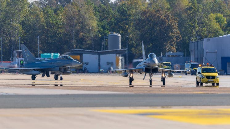 Eurofighters at Nuremberg Airport: German Air Force Conducts Dispersed Operation Drill, Nuremberg, October 5, 2026 Two German Air Force Eurofighters taxi across the apron at the airport, accompanied by a yellow Follow Me vehicle. The German Air Force is testing there how fighter jets and emergency response teams can temporarily operate out of a civilian airport. Nur 20261005-1V9A1091-M4000