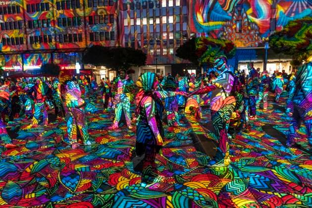 Essen Light Festival, in the city center; the light installation Diving in the Sea of Colors by Berlin-based artist Daniel Margraf illuminates the buildings on the large Kennedy Platz; visitors become part of the light art installation; North Rhine-Westphalia, Germany; Essen Light Festival