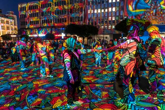 Essen Light Festival, in the city center; the light installation Diving in the Sea of Colors by Berlin-based artist Daniel Margraf illuminates the buildings on the large Kennedy Platz; visitors become part of the light art installation; North Rhine-Westphalia, Germany; Essen Light Festival