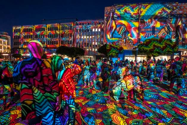 Essen Light Festival, in the city center; the light installation Diving in the Sea of Colors by Berlin-based artist Daniel Margraf illuminates the buildings on the large Kennedy Platz; visitors become part of the light art installation; North Rhine-Westphalia, Germany; Essen Light Festival