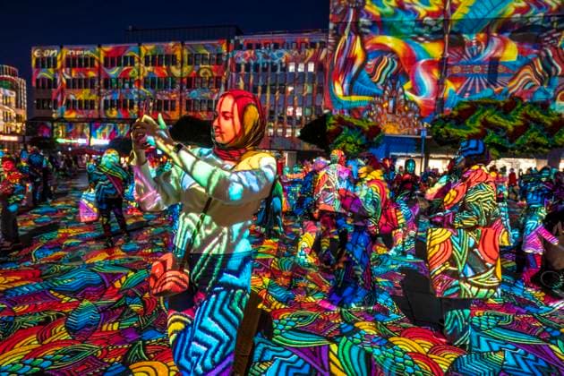 Essen Light Festival, in the city center; the light installation Diving in the Sea of Colors by Berlin-based artist Daniel Margraf illuminates the buildings on the large Kennedy Platz; visitors become part of the light art installation; North Rhine-Westphalia, Germany; Essen Light Festival