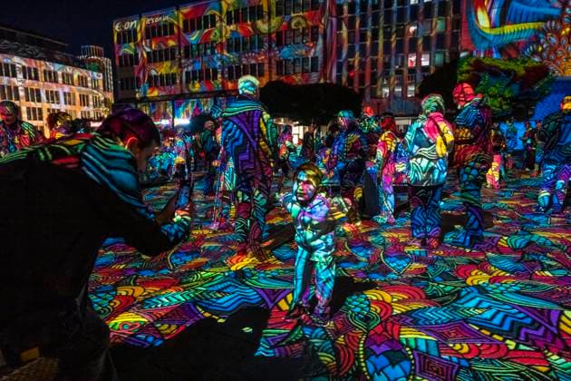 Essen Light Festival, in the city center; the light installation Diving in the Sea of Colors by Berlin-based artist Daniel Margraf illuminates the buildings on the large Kennedy Platz; visitors become part of the light art installation; North Rhine-Westphalia, Germany; Essen Light Festival