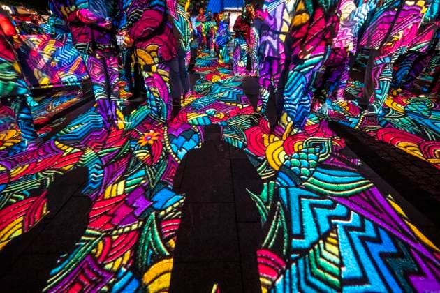 Essen Light Festival, in the city center; the light installation Diving in the Sea of Colors by Berlin-based artist Daniel Margraf illuminates the buildings on the large Kennedy Platz; visitors become part of the light art installation; North Rhine-Westphalia, Germany; Essen Light Festival