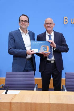 Federal Press Conference, Presentation of the Study on Artificial Intelligence Security in the German Economy: Thomas Caspers, together with Dr. Dirk Stenkamp, holding a copy of the study during the presentation of the study on artificial intelligence security in the German economy. Risks, AI security incide