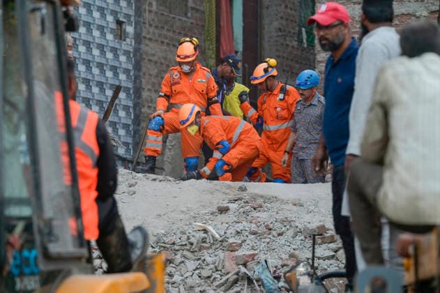 NEW DELHI, INDIA - OCTOBER 7: National Disaster Response Force (NDRF) jawans, Delhi Fire Service personnel, and local residents navigate heavy rubble during a search and rescue operation after a four-storey residential building collapsed in the New Seemapuri area of Shahdara on October 7, 2026, in New Delhi, India. The structural collapse occurred around 3:30 PM behind the local fish market, trapping multiple residents under concrete slabs and damaging two adjoining houses. At least one minor died while eight people were rescued and rushed to Rajiv Gandhi Super Speciality Hospital for emergency medical treatment as sniffer dogs and excavators worked late into the evening to locate remaining trapped survivors. (Photo by Raj K Raj Hindustan T