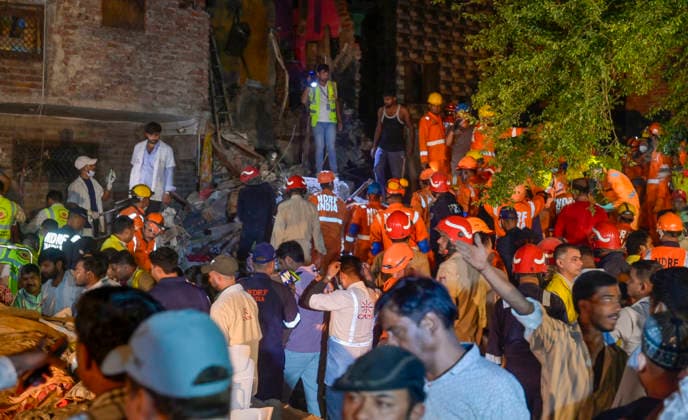 NEW DELHI, INDIA - OCTOBER 7: National Disaster Response Force (NDRF) jawans, Delhi Fire Service personnel, and local residents navigate heavy rubble during a search and rescue operation after a four-storey residential building collapsed in the New Seemapuri area of Shahdara on October 7, 2026, in New Delhi, India. The structural collapse occurred around 3:30 PM behind the local fish market, trapping multiple residents under concrete slabs and damaging two adjoining houses. At least one minor died while eight people were rescued and rushed to Rajiv Gandhi Super Speciality Hospital for emergency medical treatment as sniffer dogs and excavators worked late into the evening to locate remaining trapped survivors. (Photo by Raj K Raj Hindustan T
