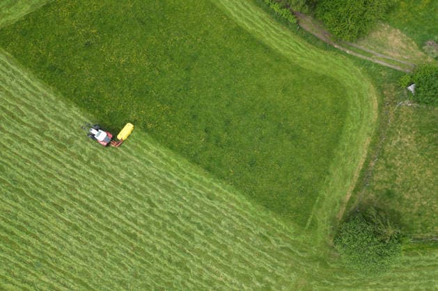 NRW, Tractor mows meadow in Siegerland