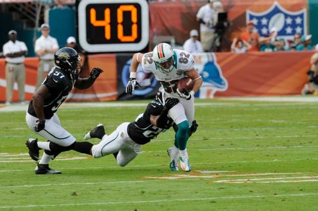 NFL, American Football Herren, USA Jaguars vs Dolphins DEC 16 December 16, 2012: Brian Hartline 82 of the Miami Dolphins tries to avoid the tackle by Dwight Lowery 25 of the Jacksonville Jaguars during the NFL football game between the Miami Dolphins and Jacksonville Jaguars at Sun Life Stadium in Miami Gardens FL. The Dolphins defeated the Jaguars 24-3. Miami Gardens FL U.S. EDITORIAL USE ONLY Copyright: xx ZUMA-20121216_zaf_cd5_107.jpg JCxRidleyx csmphoto689220