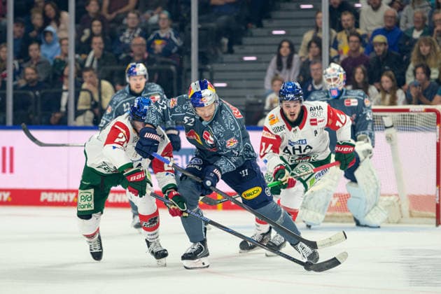 Hockey, DEL, 20261004, EHC Red Bull Munich vs. Augsburg Panthers. Pictured, from left: Alexander Blank (Augsburg, 26), Patrick Hager (Munich, 52), and D. J. Busdeker (Augsburg, 14). Munich SAP Garden, Bavaria, Germany Copyright: Passion2Press MarkusxFischerx