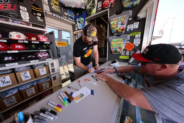 LAS VEGAS, NV - OCTOBER 04: Chase Briscoe ( 19 Joe Gibbs Racing Bass Pro Shops Toyota) signs a hero card for a fan in the Joe Gibbs Racing Merchandise Trailer during a meet and greet before the NASCAR, Motorsport, USA Cup Series Playoffs South Point 400 on October 4, 2026, at Las Vegas Motor Speedway in Las Vegas, NV. (Photo by Marc Sanchez Icon Sportswire) AUTO: OCT 04 NASCAR Cup Series Playoffs South Point 400 EDITORIAL USE ONLY Icon14426100401090