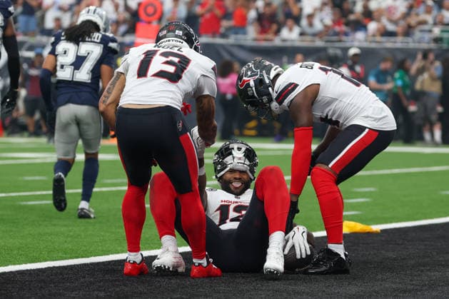 HOUSTON, TX - OCTOBER 04: Wide receiver Nico Collins 12 of the Houston Texans smiles after getting a touchdown and as wide receiver Jaylin Noel 13 of the Houston Texans and wide receiver Kayshon Boutte 14 of the Houston Texans help him up during the NFL, American Football Herren, USA football game between the Houston Texans and Dallas Cowboys on October 4, 2026, at Reliant Stadium in Houston, TX. (Photo by David Buono Icon Sportswire) NFL: OCT 04 Cowboys at Texans EDITORIAL USE ONLY Icon241004190
