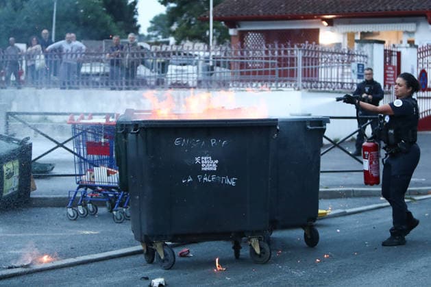 October 1, 2026, Anglet, Nouvelle Aquitaine, France: A police officer uses a fire extinguisher to put out a burning garbage container set on fire by protesters during a protest outside the Lyco e Cantau in Anglet, southwestern France, on October 1, 2026, against overcrowded classes and a lack of resources. The movement, which began in the Paris region a week ago, has spread across France, with hundreds of high schools blocked. Anglet France - ZUMAb298 20261001_zsp_b298_013 Copyright: xJulesxBuonx