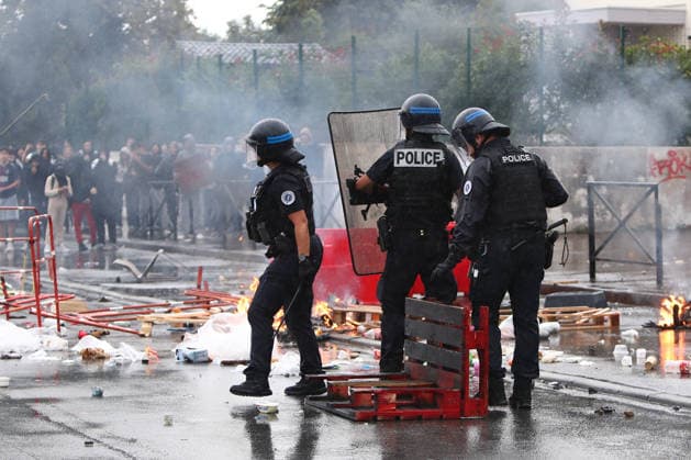 October 1, 2026, Anglet, Nouvelle Aquitaine, France: Police officers in riot gear stand behind a burning barricade of pallets and barriers as protesters watch from a distance during a protest outside the Lyco e Cantau in Anglet, southwestern France, on October 1, 2026, against overcrowded classes and a lack of resources. The movement, which began in the Paris region a week ago, has spread across France, with hundreds of high schools blocked. Anglet France - ZUMAb298 20261001_zsp_b298_011 Copyright: xJulesxBuonx