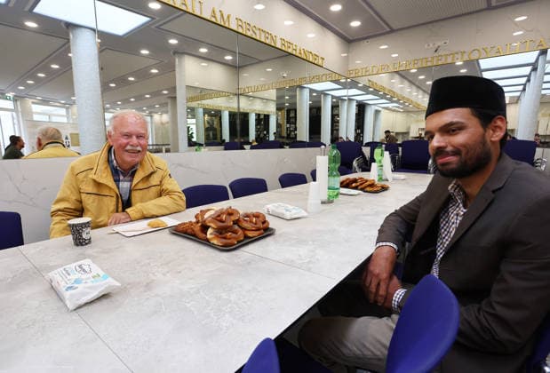 Open Mosque Day in Germany Open Mosque Day in Germany. A men from nuremberg and a muslim member smile together in the mosque Bait ur Rehman Moschee in Nuremberg, Germany . October 03rd , 2026 Photo by Davide Elias Copyright: xDavidexEliasx