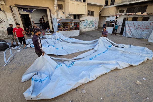 Palestinian Tailor Repairs Tent Covers for Displaced Families in Khan Younis Palestinian tailor Shaaban al-Tabash repairs and assembles tarpaulins and plastic sheets using rudimentary methods to reinforce the tents of displaced Palestinians and protect them from cold weather and rain in Khan Younis, in the southern Gaza Strip, on October 4, 2026. As winter approaches, shortages of protective supplies and the deterioration of many tents after nearly three years of war are worsening living conditions, while al-Tabash uses available materials to extend the life of shelters that have become the last refuge for thousands of displaced people. Photo by Tariq Mohammad APA Images Khan Yunis Gaza Strip Palestinian Territory 041026_Khan_Yunis_TM_01( Copyright: xapaimagesxTariqxMohammad xapaimagesx