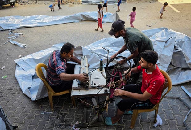 Palestinian Tailor Repairs Tent Covers for Displaced Families in Khan Younis Palestinian tailor Shaaban al-Tabash repairs and assembles tarpaulins and plastic sheets using rudimentary methods to reinforce the tents of displaced Palestinians and protect them from cold weather and rain in Khan Younis, in the southern Gaza Strip, on October 4, 2026. As winter approaches, shortages of protective supplies and the deterioration of many tents after nearly three years of war are worsening living conditions, while al-Tabash uses available materials to extend the life of shelters that have become the last refuge for thousands of displaced people. Photo by Tariq Mohammad APA Images Khan Yunis Gaza Strip Palestinian Territory 041026_Khan_Yunis_TM_01( Copyright: xapaimagesxTariqxMohammad xapaimagesx