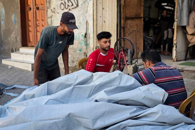 Palestinian Tailor Repairs Tent Covers for Displaced Families in Khan Younis Palestinian tailor Shaaban al-Tabash repairs and assembles tarpaulins and plastic sheets using rudimentary methods to reinforce the tents of displaced Palestinians and protect them from cold weather and rain in Khan Younis, in the southern Gaza Strip, on October 4, 2026. As winter approaches, shortages of protective supplies and the deterioration of many tents after nearly three years of war are worsening living conditions, while al-Tabash uses available materials to extend the life of shelters that have become the last refuge for thousands of displaced people. Photo by Tariq Mohammad APA Images Khan Yunis Gaza Strip Palestinian Territory 041026_Khan_Yunis_TM_01( Copyright: xapaimagesxTariqxMohammad xapaimagesx