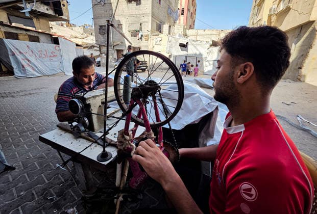 Palestinian Tailor Repairs Tent Covers for Displaced Families in Khan Younis Palestinian tailor Shaaban al-Tabash repairs and assembles tarpaulins and plastic sheets using rudimentary methods to reinforce the tents of displaced Palestinians and protect them from cold weather and rain in Khan Younis, in the southern Gaza Strip, on October 4, 2026. As winter approaches, shortages of protective supplies and the deterioration of many tents after nearly three years of war are worsening living conditions, while al-Tabash uses available materials to extend the life of shelters that have become the last refuge for thousands of displaced people. Photo by Tariq Mohammad APA Images Khan Yunis Gaza Strip Palestinian Territory 041026_Khan_Yunis_TM_01( Copyright: xapaimagesxTariqxMohammad xapaimagesx