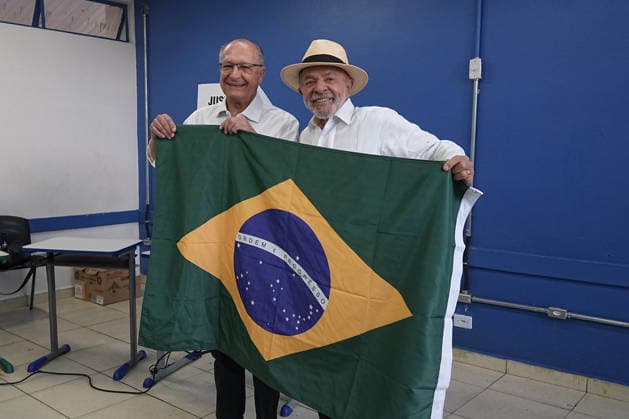 (261004) -- BRASILIA, Oct. 4, 2026 -- Brazilian President Luiz Inacio Lula da Silva (R), presidential candidate of Brazil s ruling Workers Party, displays a national flag of Brazil after casting his ballot at a polling station in Sao Bernardo do Campo, Brazil, Oct. 4, 2026. Voting in the first round of Brazil s 2026 presidential election officially began at 8 a.m. (1100 GMT) on Sunday, with polling stations across the country scheduled to close at 5 p.m. (0800 GMT). Initial results are expected to be announced within a few hours after the polls close. (Photo by Xinhua) BRAZIL-PRESIDENTIAL ELECTION-VOTING PauloxLopes